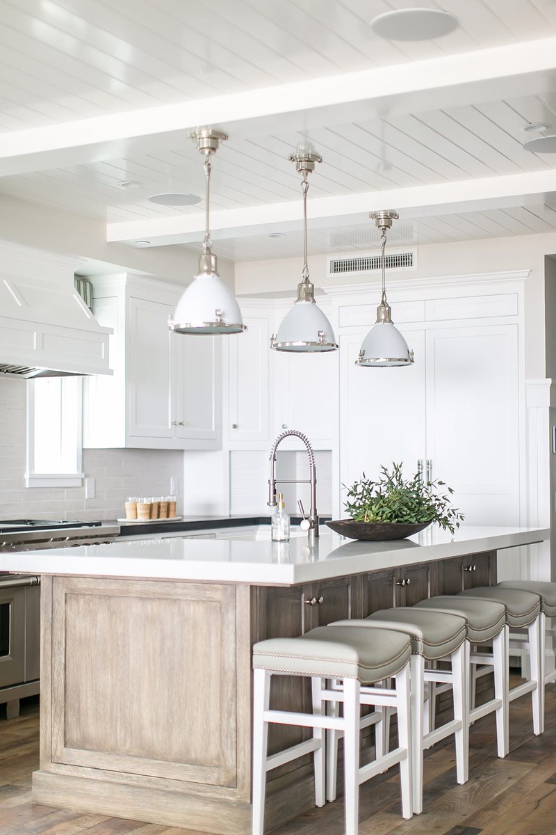 White kitchen design with light wooden cabinets and detailed ceilings