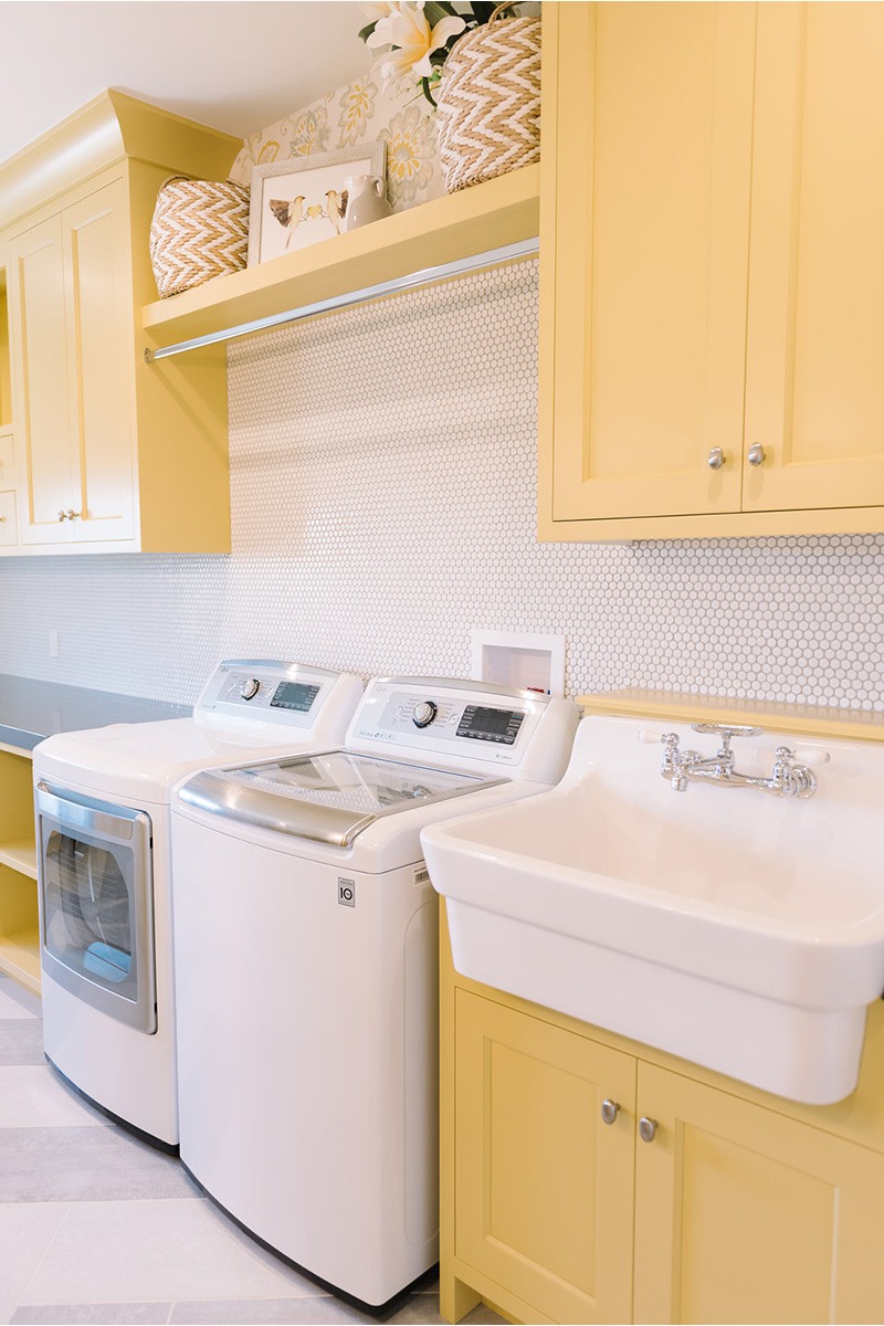 Yellow Shaker Laundry Room Cabinets with White Hex Tile Backsplash