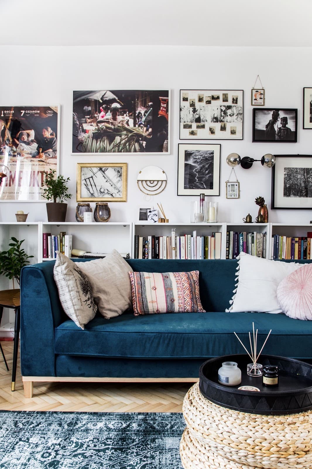 Living room with blue velvet sofa and art wall gallery