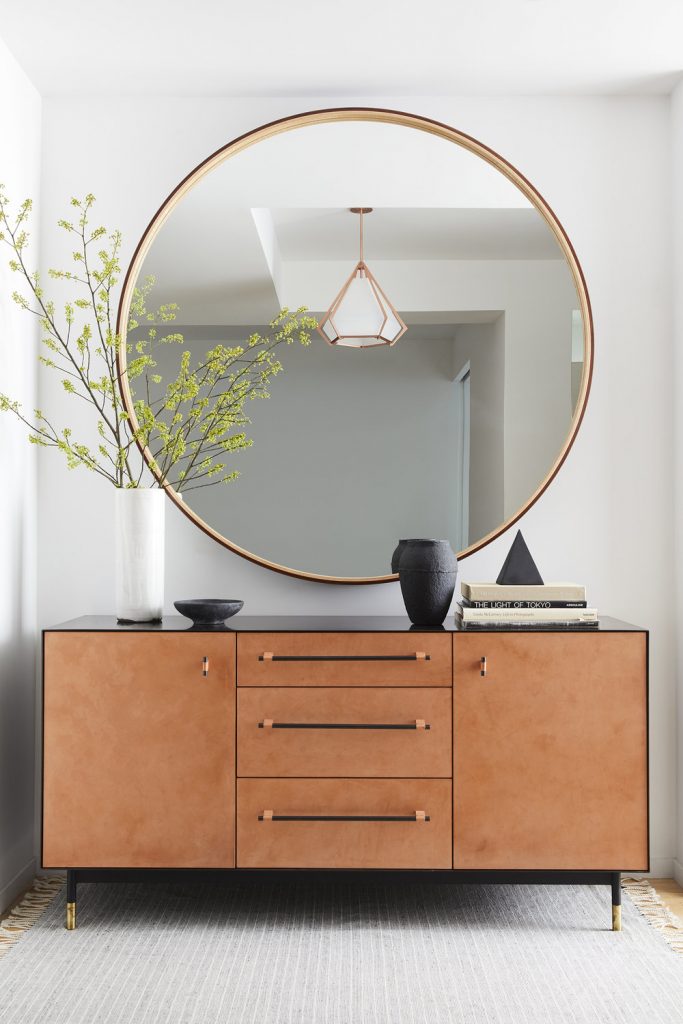 Minimalistic entry table décor with large rounded mirror