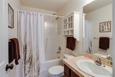 A bathroom with a bathtub and curtain.