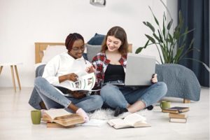Two women working on laptop.